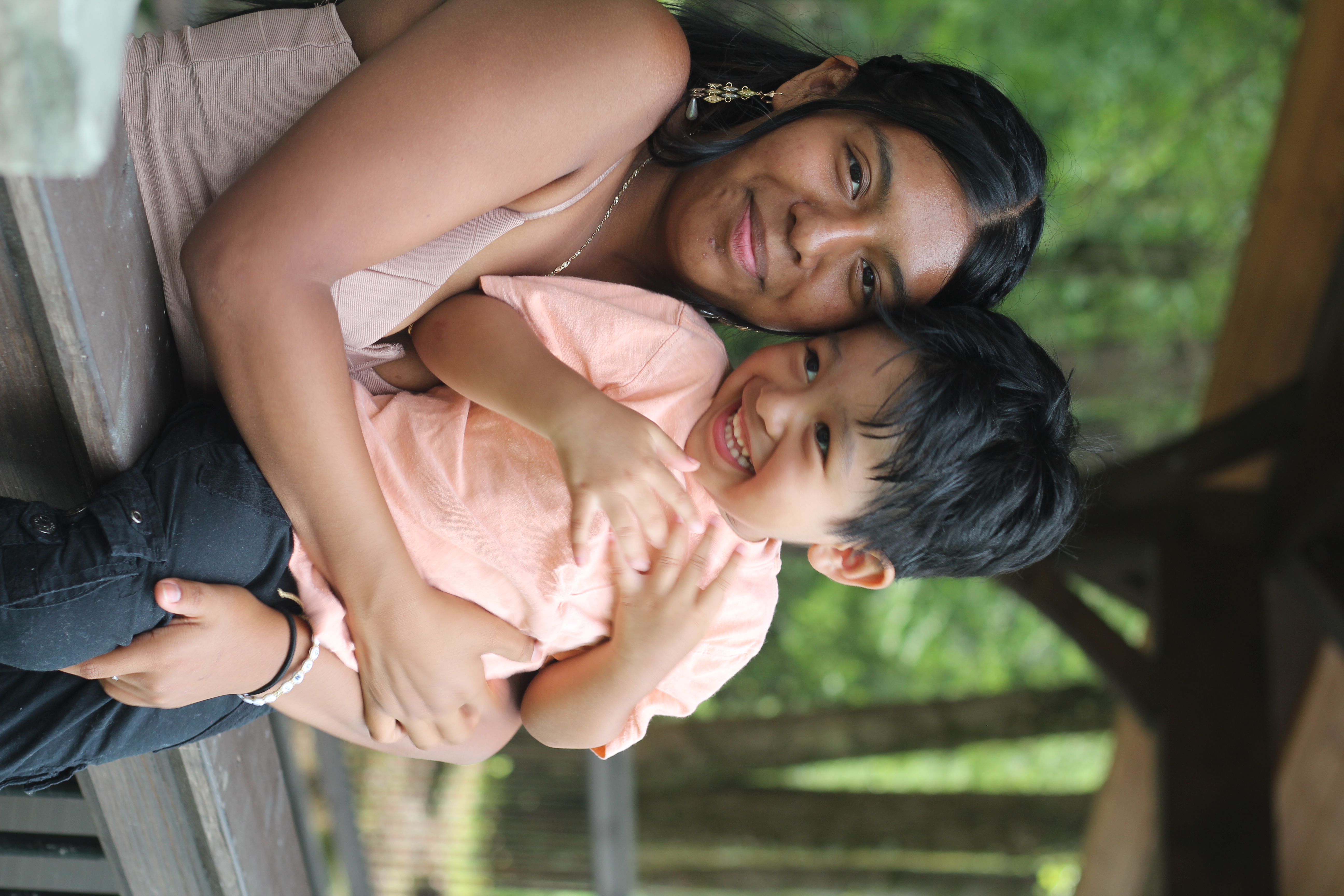 A teen mom embracing her smiling toddler